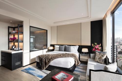 a bedroom with a king sized bed and a living room at Ascott Thonglor Bangkok in Bangkok
