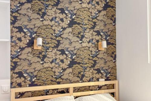 - une chambre avec un mur orné d'un papier peint à fleurs dans l'établissement Flexliving - studio - 3 Portes, à Paris