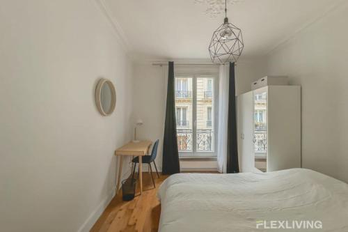 une chambre avec un lit, un bureau et une fenêtre dans l'établissement Flexliving - room - Sophie Germain, à Paris
