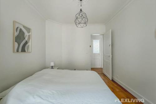 une chambre blanche avec un grand lit dedans dans l'établissement Flexliving - room - Sophie Germain, à Paris