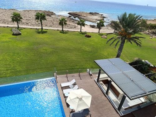 a swimming pool with a deck and a view of the beach at Beachfront Luxury Villa Glory in Ayia Napa
