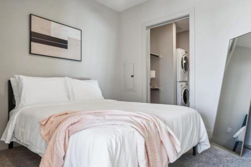 a bedroom with a white bed with a pink blanket on it at Indie Deep Ellum in Dallas in Dallas