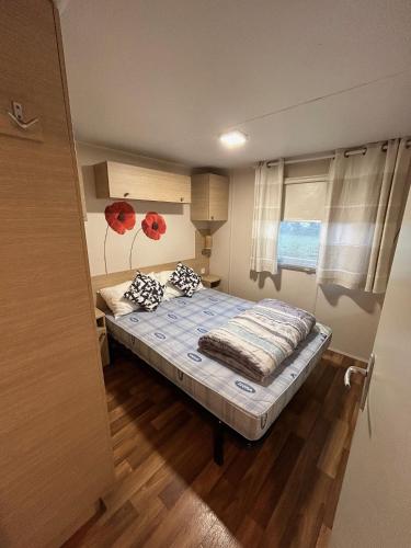 - une petite chambre avec un lit et des oreillers dans l'établissement Mobil home finistère sud 2CH 4PERS, à Clohars-Carnoët