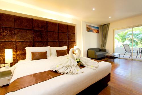 a bedroom with a large white bed with flowers on it at Pooh Beach Resort & Spa in Jomtien Beach