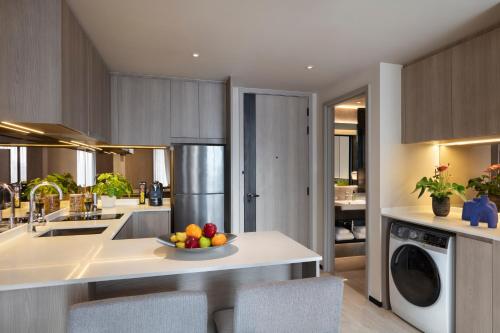 a kitchen with a bowl of fruit on a counter at Ascott Thonglor Bangkok in Bangkok