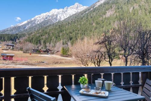 d'une table sur un balcon avec vue sur la montagne. dans l'établissement Appartement des Champs - Welkeys, à Chamonix-Mont-Blanc