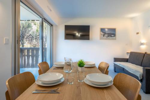 une salle à manger avec une table et des chaises en bois dans l'établissement Appartement des Champs - Welkeys, à Chamonix-Mont-Blanc