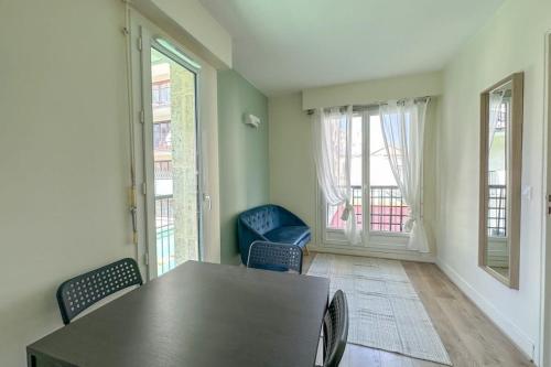 une salle à manger avec une table, des chaises et des fenêtres dans l'établissement Flexliving - Splendid whole apartment - Croix Nivert, à Paris