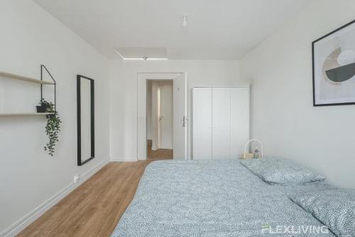 - une chambre blanche avec un lit et une couverture bleue dans l'établissement Flexliving - Beautiful R5 flat - Henri Sellier - Suresnes 92, à Suresnes