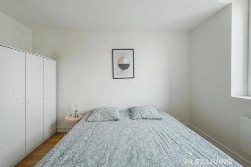 une chambre blanche avec un lit et une table dans l'établissement Flexliving - Beautiful R5 flat - Henri Sellier - Suresnes 92, à Suresnes