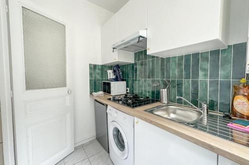 une cuisine avec un évier et une machine à laver dans l'établissement Flexliving - Whole flat - Balard, à Paris