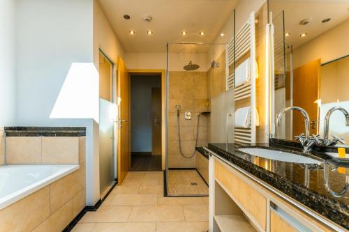 a bathroom with two sinks and a tub and a shower at Berghotel Rehlegg in Ramsau