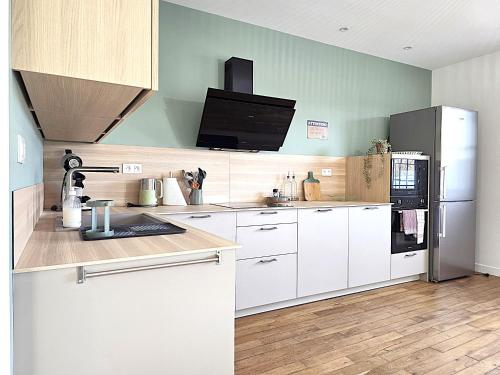 a kitchen with white cabinets and a refrigerator at Belle Villa au cœur du frontonnais - Cœur de village - Piscine, jardin et terrasses privés - Climatisation - 8 personnes - 5 lits in Fronton