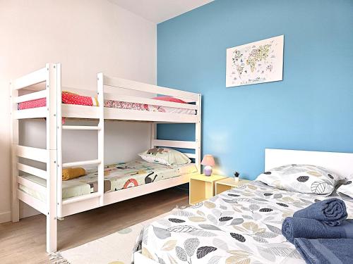 a bedroom with two bunk beds and a blue wall at Belle Villa au cœur du frontonnais - Cœur de village - Piscine, jardin et terrasses privés - Climatisation - 8 personnes - 5 lits in Fronton