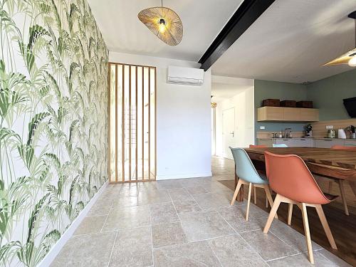 a kitchen with a dining table and two chairs at Belle Villa au cœur du frontonnais - Cœur de village - Piscine, jardin et terrasses privés - Climatisation - 8 personnes - 5 lits in Fronton