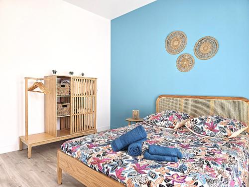 a bedroom with a bed with a blue wall at Belle Villa au cœur du frontonnais - Cœur de village - Piscine, jardin et terrasses privés - Climatisation - 8 personnes - 5 lits in Fronton