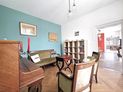a living room with a piano and a table at Belle Villa au cœur du frontonnais - Cœur de village - Piscine, jardin et terrasses privés - Climatisation - 8 personnes - 5 lits in Fronton
