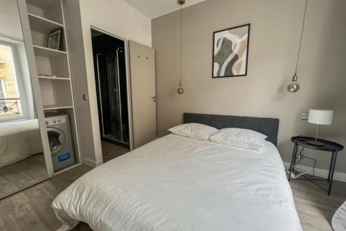 une chambre avec un grand lit blanc et une fenêtre dans l'établissement Flexliving - Beautiful 2-room apartment - Chaussée d'Antin - Paris 09, à Paris