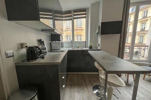 - une cuisine avec un comptoir, un évier et une table dans l'établissement Flexliving - Beautiful 2-room apartment - Chaussée d'Antin - Paris 09, à Paris
