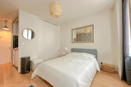 une chambre blanche avec un lit et un miroir dans l'établissement Flexliving - Lappe - Studio, à Paris