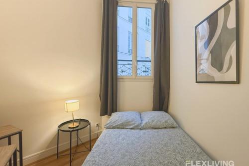 une petite chambre avec un lit et une fenêtre dans l'établissement Flexliving - Studio - La Fayette, à Paris