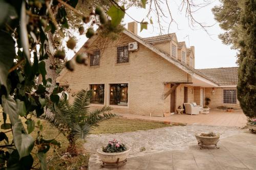 a large brick house with a patio in front of it at Vega de la Reina in Jaén