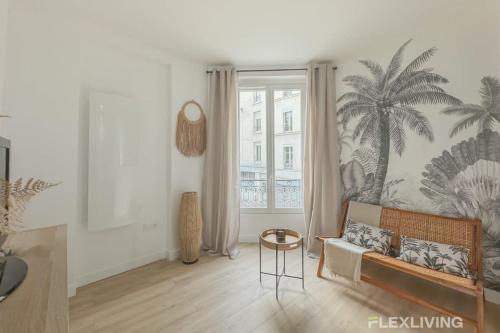 - un salon avec un canapé et une fresque murale de palmiers dans l'établissement Flexliving - studio - Guénot, à Paris