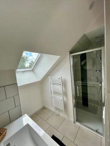 La salle de bains mansardée est pourvue d'une douche et d'un lavabo. dans l'établissement Maison cosy proche Cancale et Mont-Saint-Michel, à Saint-Méloir-des-Ondes