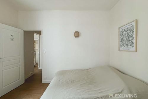 - une chambre blanche avec un lit et un couloir dans l'établissement Flexliving - whole flat - Mesnil, à Paris