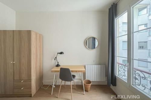 Cette chambre dispose d'un bureau et d'une chaise. dans l'établissement Flexliving - whole flat - Mesnil, à Paris
