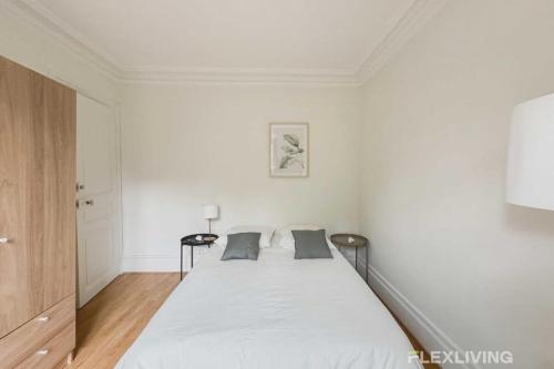 - une chambre blanche avec un grand lit et 2 oreillers dans l'établissement Flexliving - whole - Paris 18, à Paris
