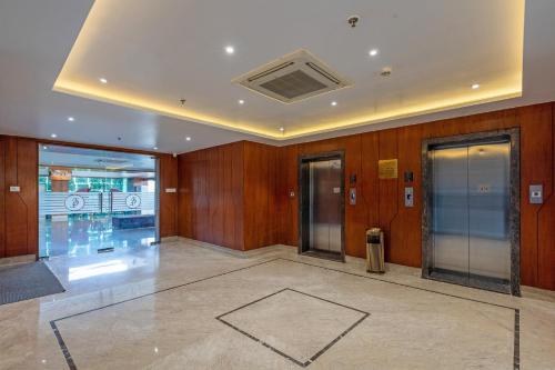 an empty lobby with two elevators in a building at The Chandra Leela Hotel in Indore