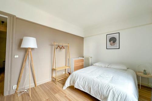 - une chambre avec un lit, une commode et une lampe dans l'établissement Flexliving - whole flate - Entrepreneur, à Paris