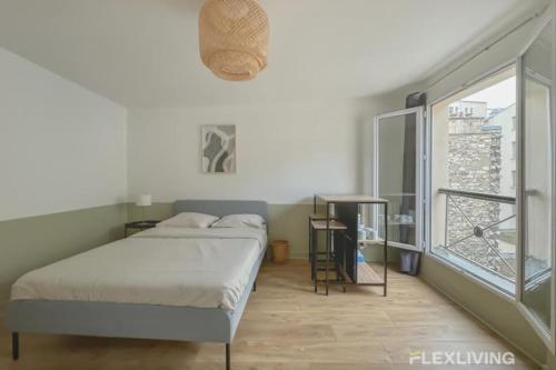 une chambre avec un lit et une grande fenêtre dans l'établissement Flexliving - Studio - Echiquier, à Paris