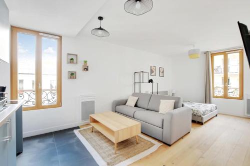 un salon avec un canapé et une table dans l'établissement Flexliving - studio - Fessart, à Paris