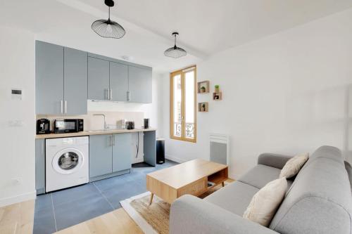 un salon avec un canapé et une cuisine dans l'établissement Flexliving - studio - Fessart, à Paris