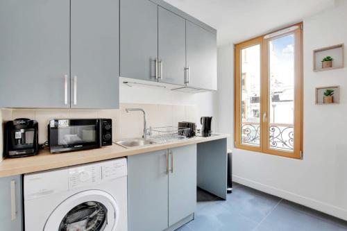 une cuisine avec une machine à laver et un évier dans l'établissement Flexliving - studio - Fessart, à Paris