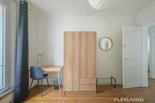 Cette chambre comprend un bureau et une armoire en bois. dans l'établissement Flexliving - room - Sophie Germain, à Paris