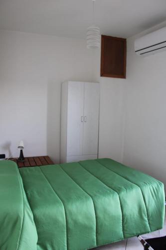 a bedroom with a green bed in a room at La collina degli ulivi in Conocchia