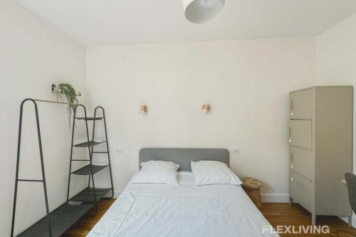 - une chambre blanche avec un lit et une échelle dans l'établissement Flexliving - whole apartment - Abbé Groult, à Paris