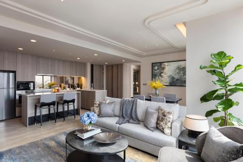 a living room with a couch and a kitchen at Ascott Thonglor Bangkok in Bangkok