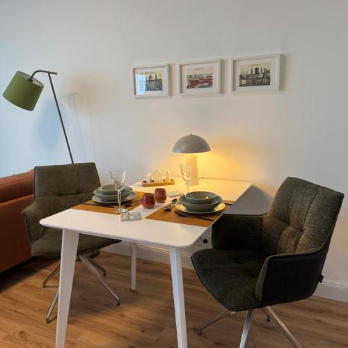 a dining room table with two chairs and a lamp at An de Waterkant in Schausende