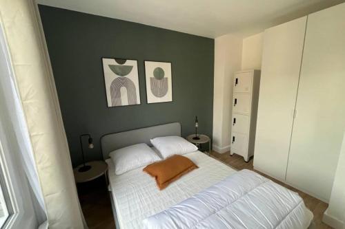 une chambre avec un lit blanc avec deux oreillers dans l'établissement Flexliving - Superb whole apartment - Caulaincourt, à Paris