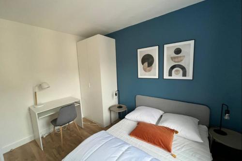 - une chambre dotée d'un mur bleu avec un lit et un bureau dans l'établissement Flexliving - Superb whole apartment - Caulaincourt, à Paris