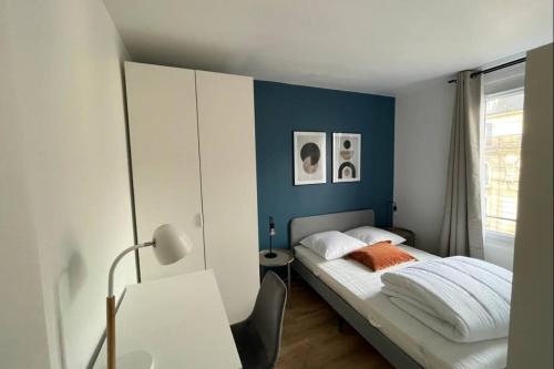 une chambre avec un lit avec un mur bleu dans l'établissement Flexliving - Superb whole apartment - Caulaincourt, à Paris