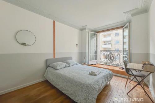 une chambre avec un lit, une table et une fenêtre dans l'établissement Flexliving - whole flat - Hameau, à Paris