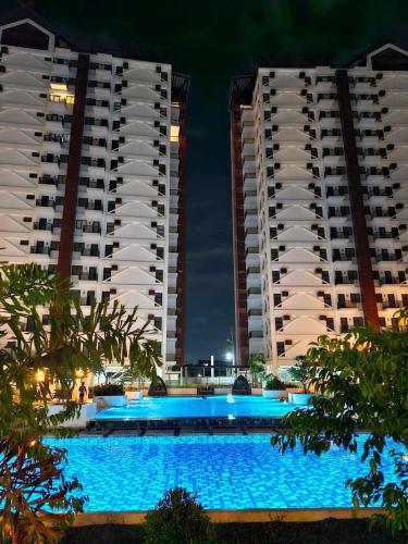 a swimming pool in front of two buildings at night at Resortstyle condo in Royal Oceancrest Mactan in Lapu Lapu City
