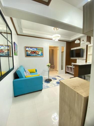 a living room with a blue couch and a kitchen at Resortstyle condo in Royal Oceancrest Mactan in Lapu Lapu City