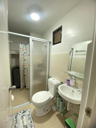 a bathroom with a toilet and a shower and a sink at Resortstyle condo in Royal Oceancrest Mactan in Lapu Lapu City