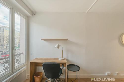 Cette chambre dispose d'un bureau, de deux chaises et d'une fenêtre. dans l'établissement Flexliving - Studio - Neuilly, à Neuilly-sur-Seine